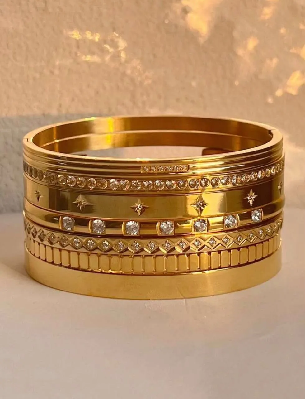 Set de brazaletes dorados apilados con circonias